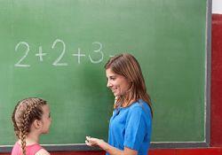 Teacher working with student at a chalkboard